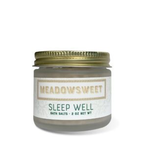 a short frosted jar with a gold lid containing Sleep Well Bath Salts.