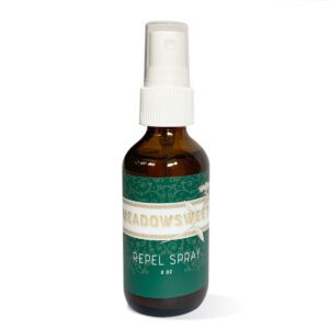 An amber bottle with white spray top containing Repel Spray essential oil blend.