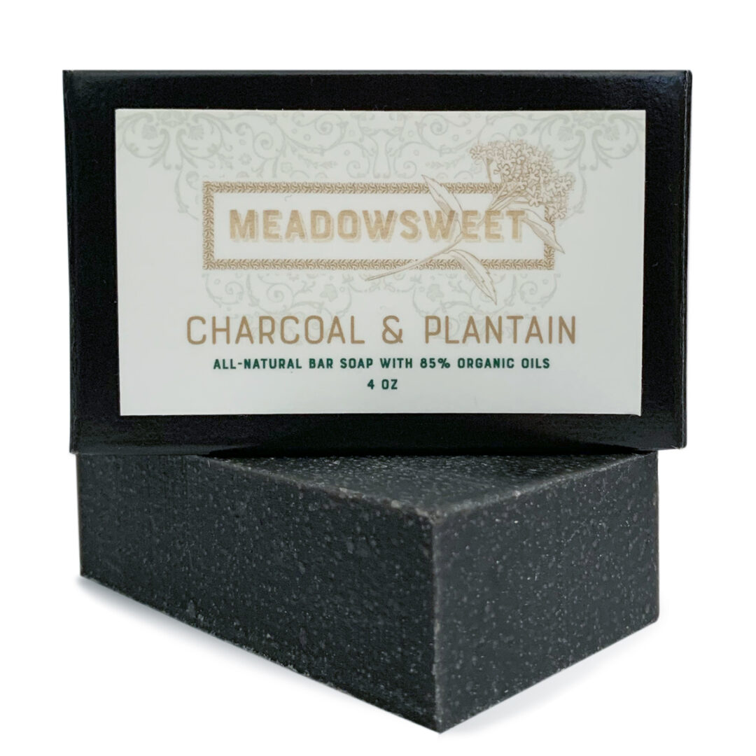 Small black box with white label. Charcoal & Plantain Bar Soap beneath the box.