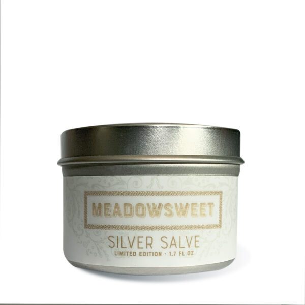 Small silver metal jar with white label containing Silver Salve.